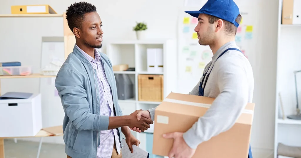 Logistics professionals handshake with package.