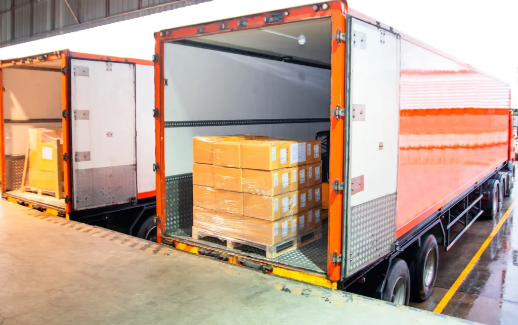 Truck driving on highway with cargo containers, representing logistics and freight transportation services.